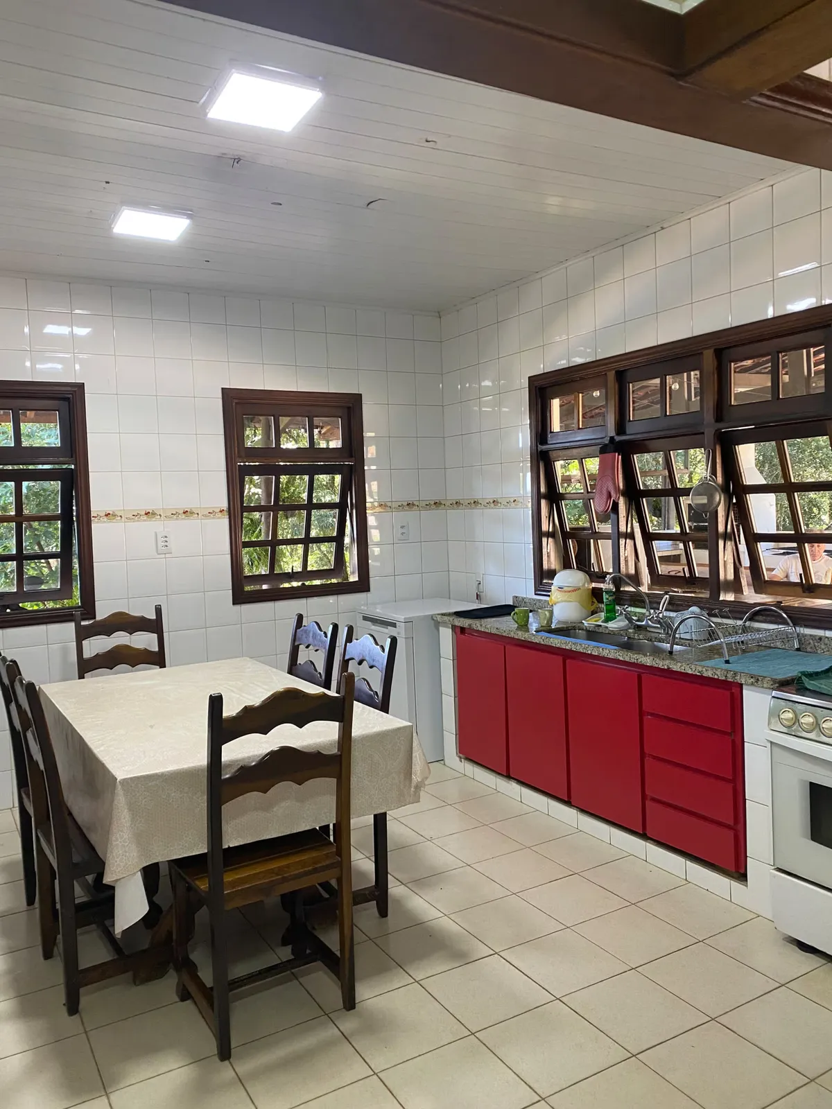 Cozinha equipada do Sítio Manacás com fogão, bancada de granito e mesa de refeições