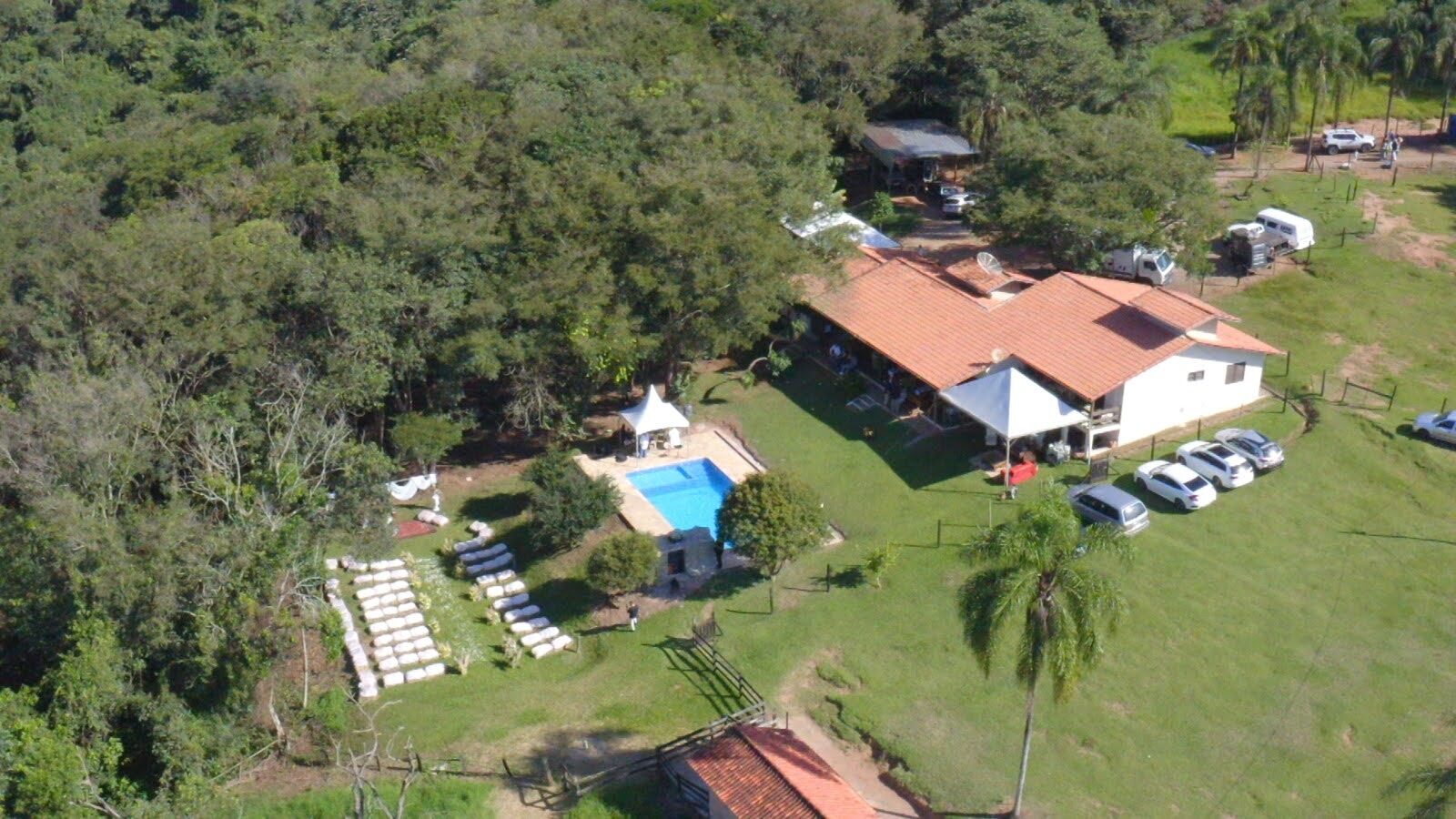 Foto aérea real do Sítio Manacás mostrando sede, piscina, bosque e cerimônia ao ar livre